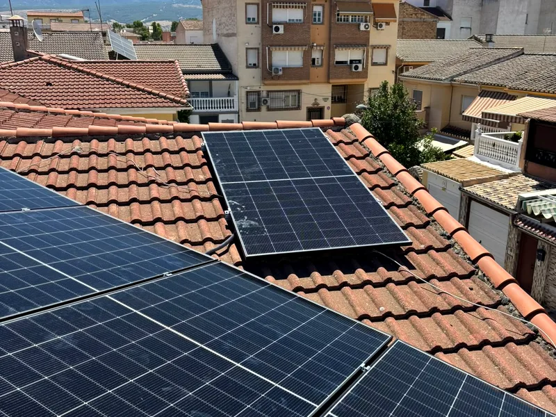 Placas solares instaladas sobre cubierta de teja en una vivienda de Granada, con Sierra Nevada al fondo